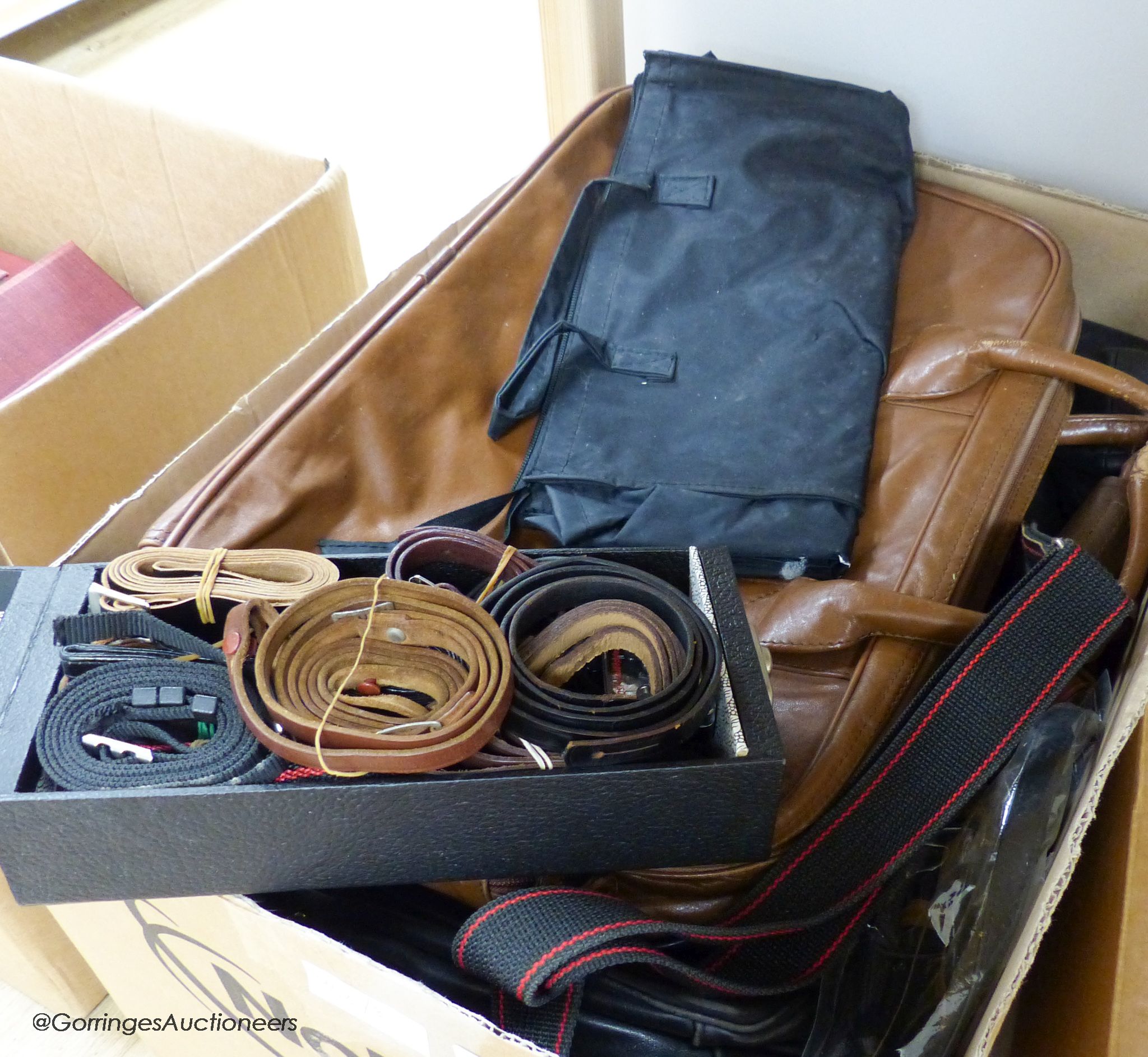 A large collection of leather camera bags, leather camera straps, etc